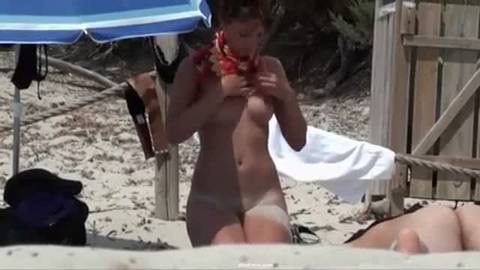 Voyeuriste observe une brunette sur la plage